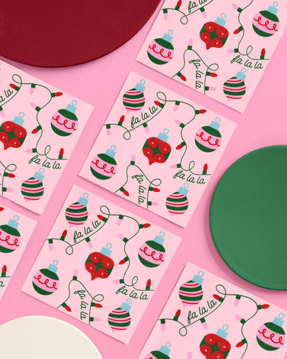 Christmas-themed stickers with ornaments and 'fa la la' text on pink paper.