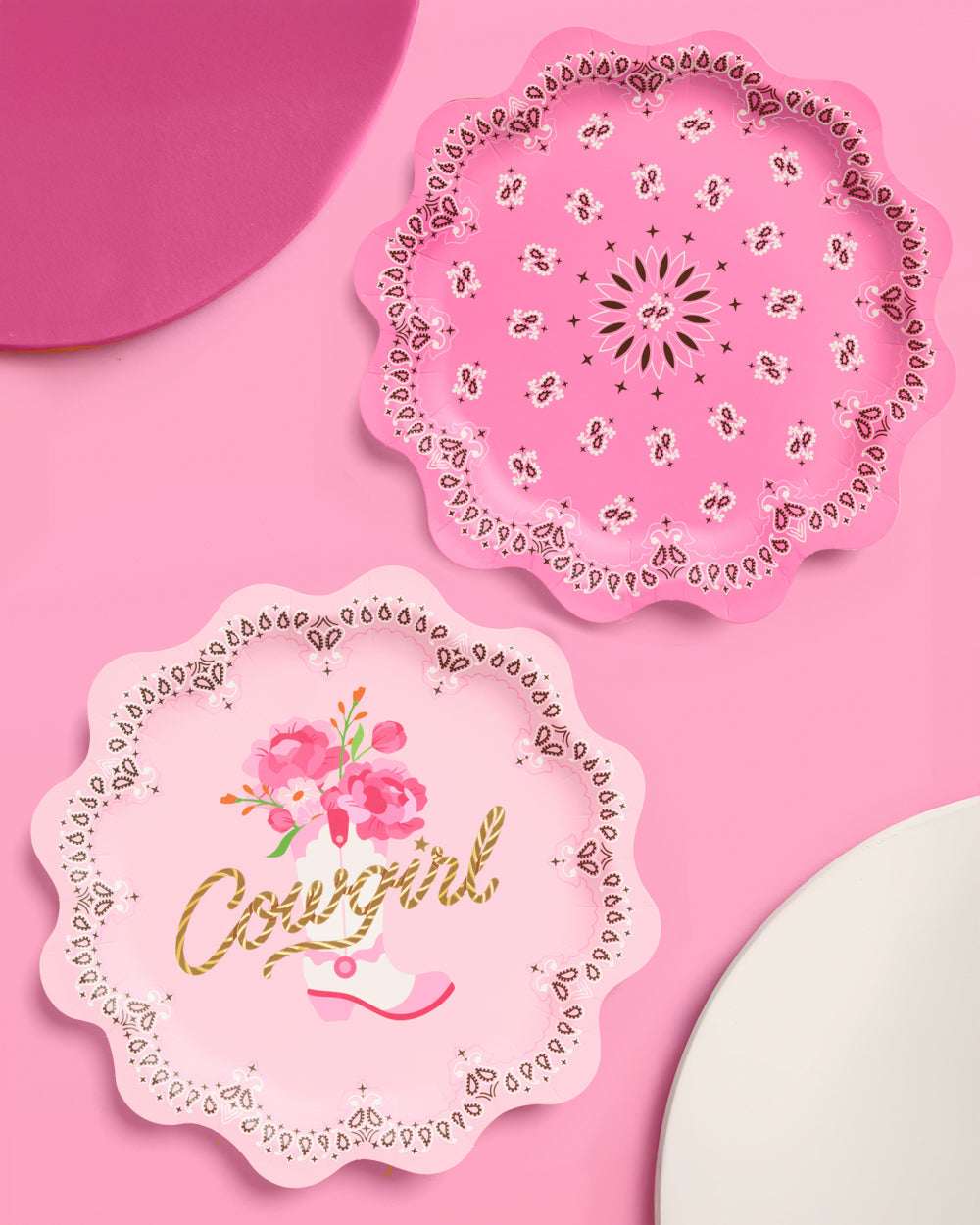 Two decorative paper plates with floral designs on a pink background