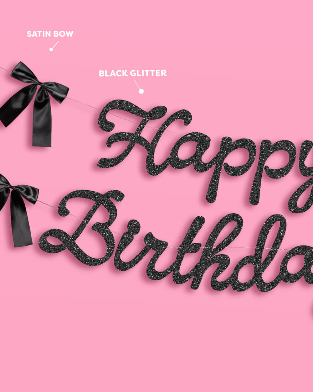 Black glitter 'Happy Birthday' banner with satin bows on a pink background