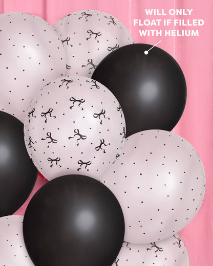Black and white balloons with decorative patterns on a pink background