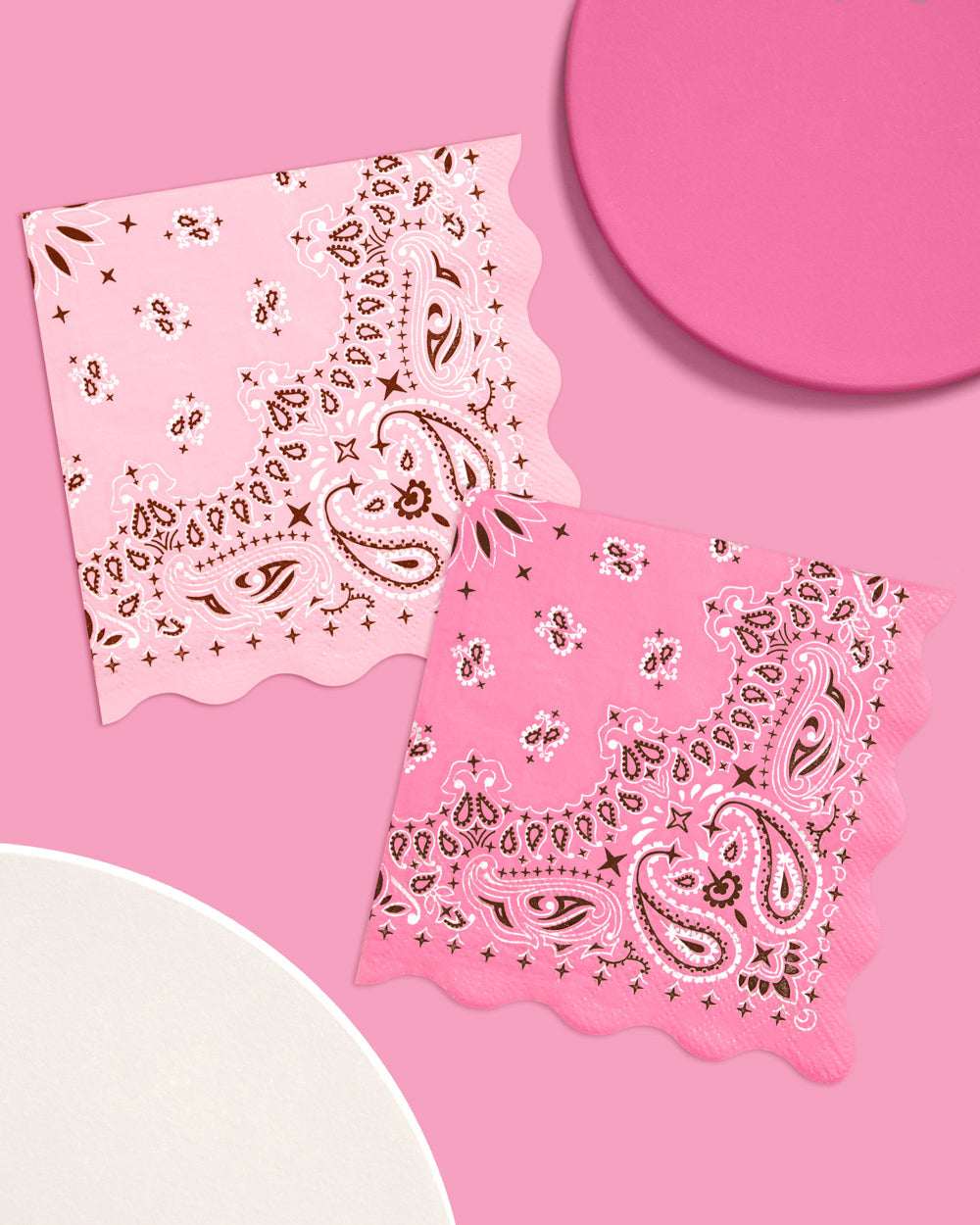 Two pink bandanas with paisley patterns on a pink background