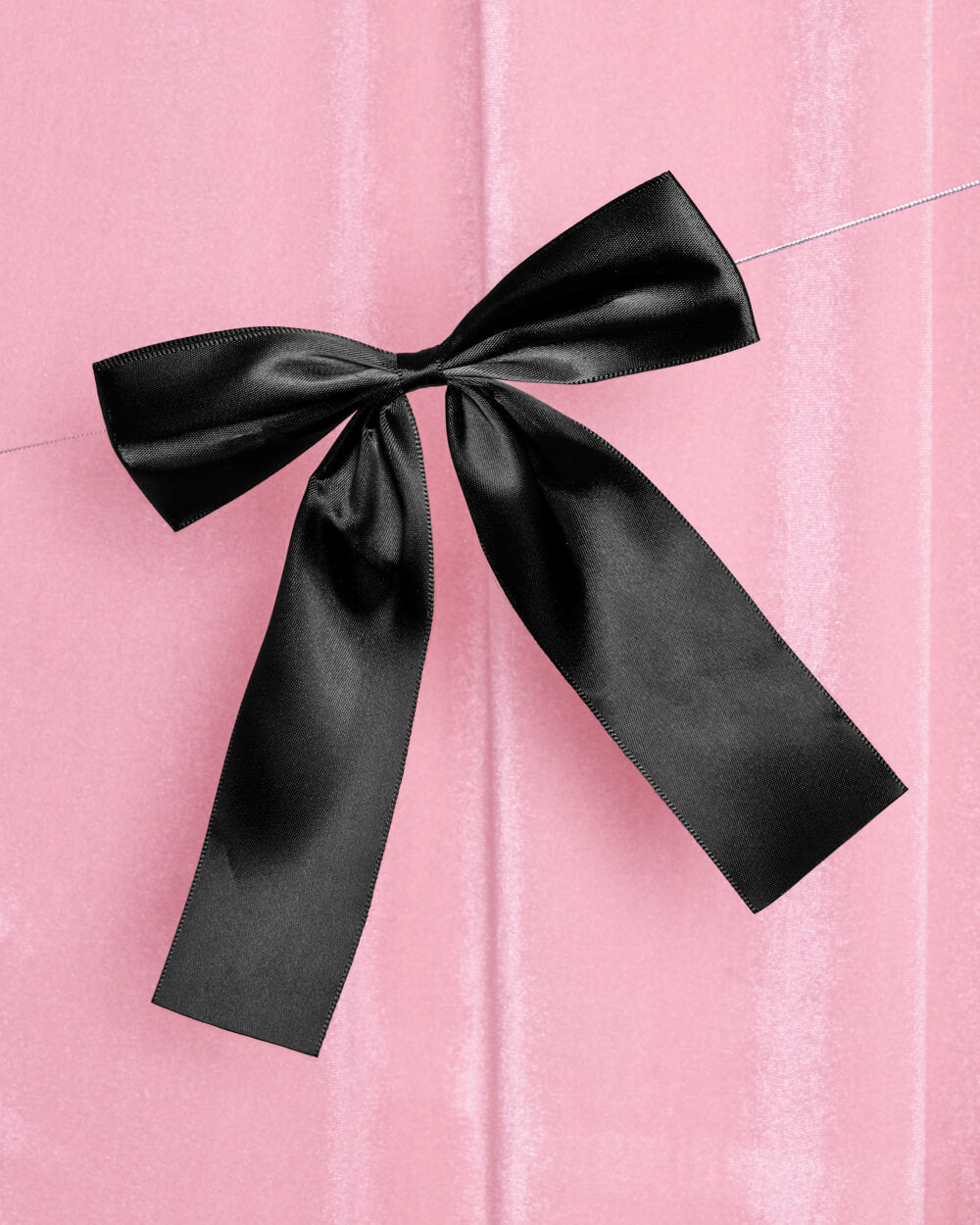 Black bow on a pink textured background