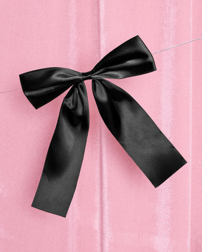 Black bow on a pink textured background