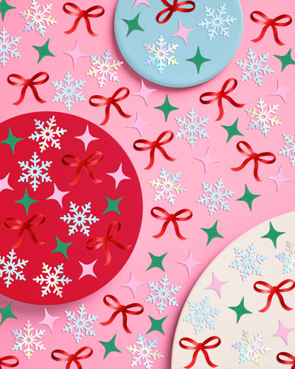 Colorful Christmas-themed pattern with bows, snowflakes, and stars on a pink background.