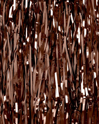 Rose gold tinsel strands against a dark background