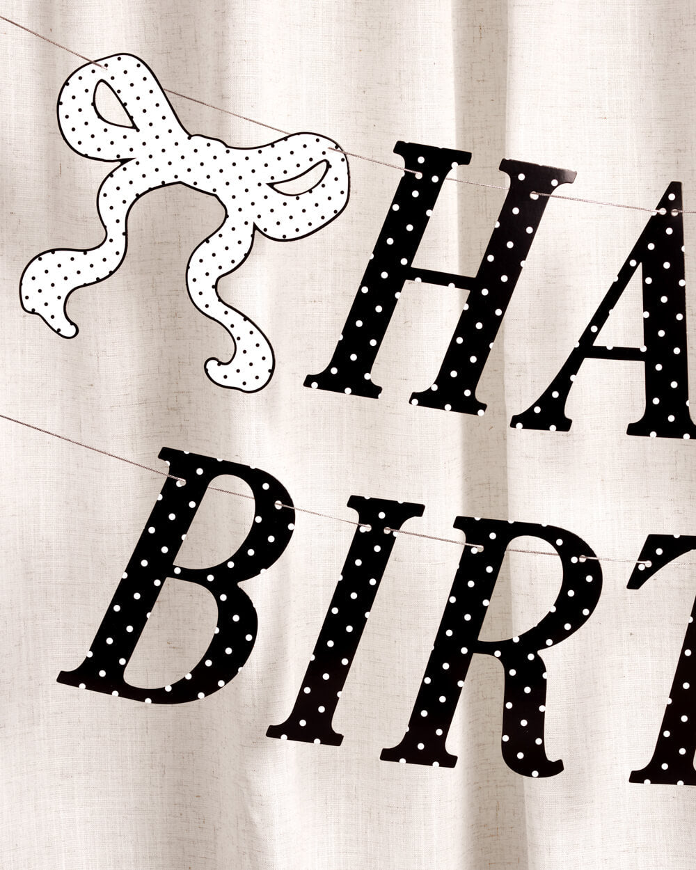 Black polka dot 'Happy Birthday' banner on a white background