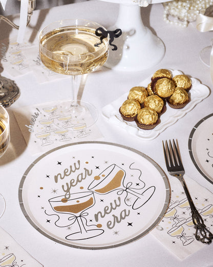 New Year's Eve table setting with champagne glasses, chocolates, and a decorative plate.