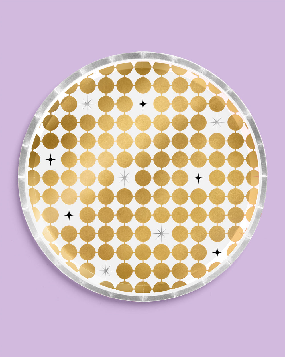 Round gold polka dot coaster on a purple background