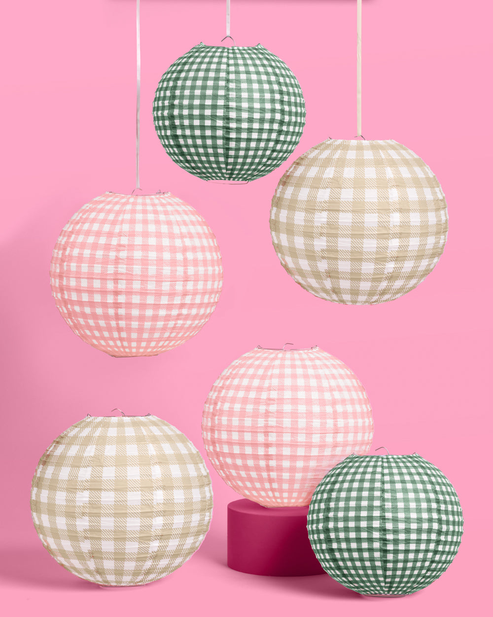 Set of gingham-patterned paper lanterns on a pink background
