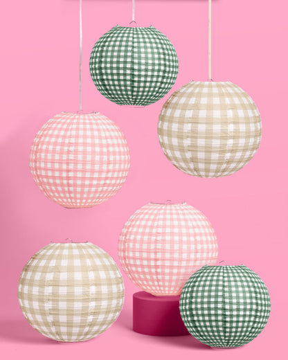 Set of gingham-patterned paper lanterns on a pink background