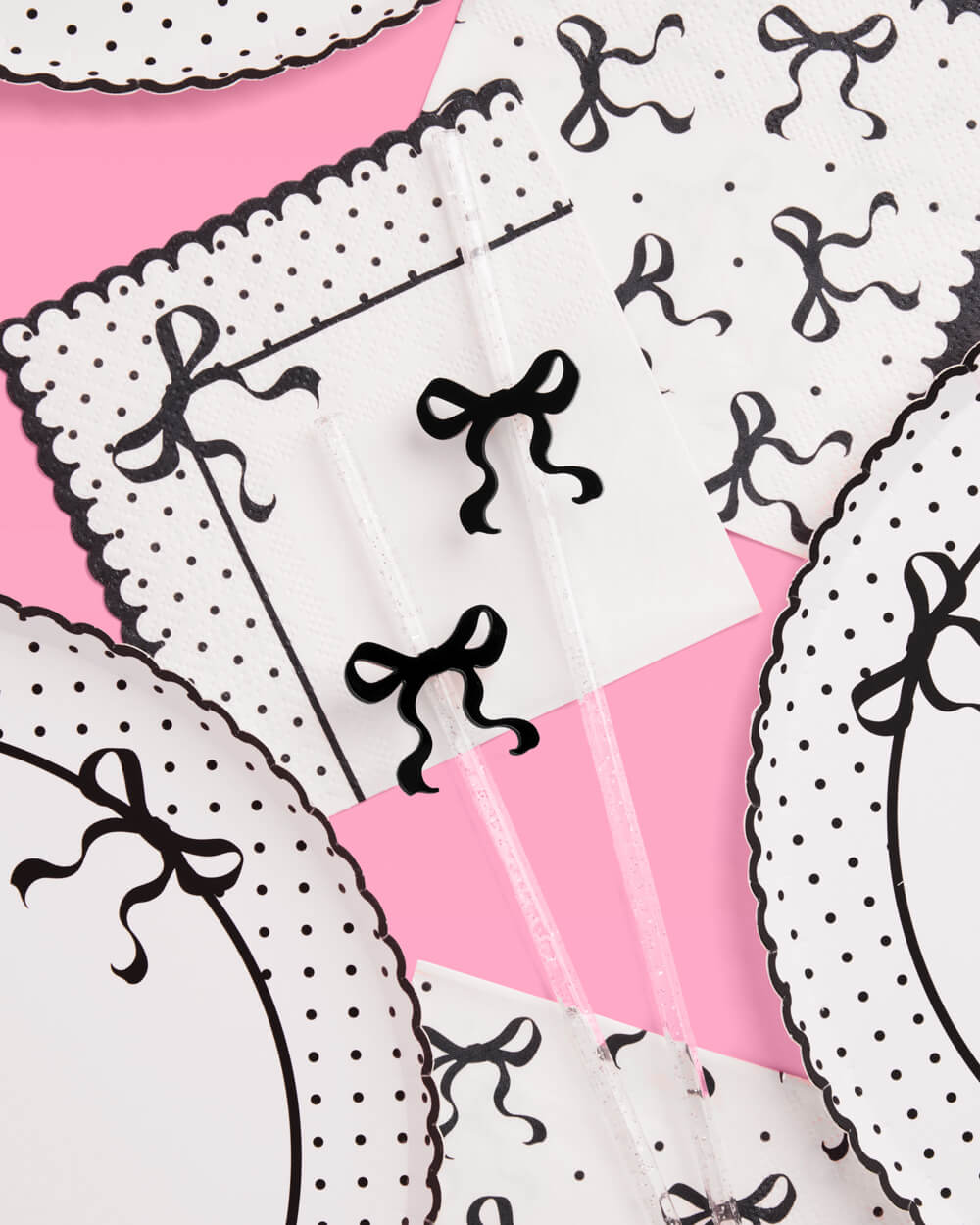 Patterned fabric with black bows and white polka dots on a pink background