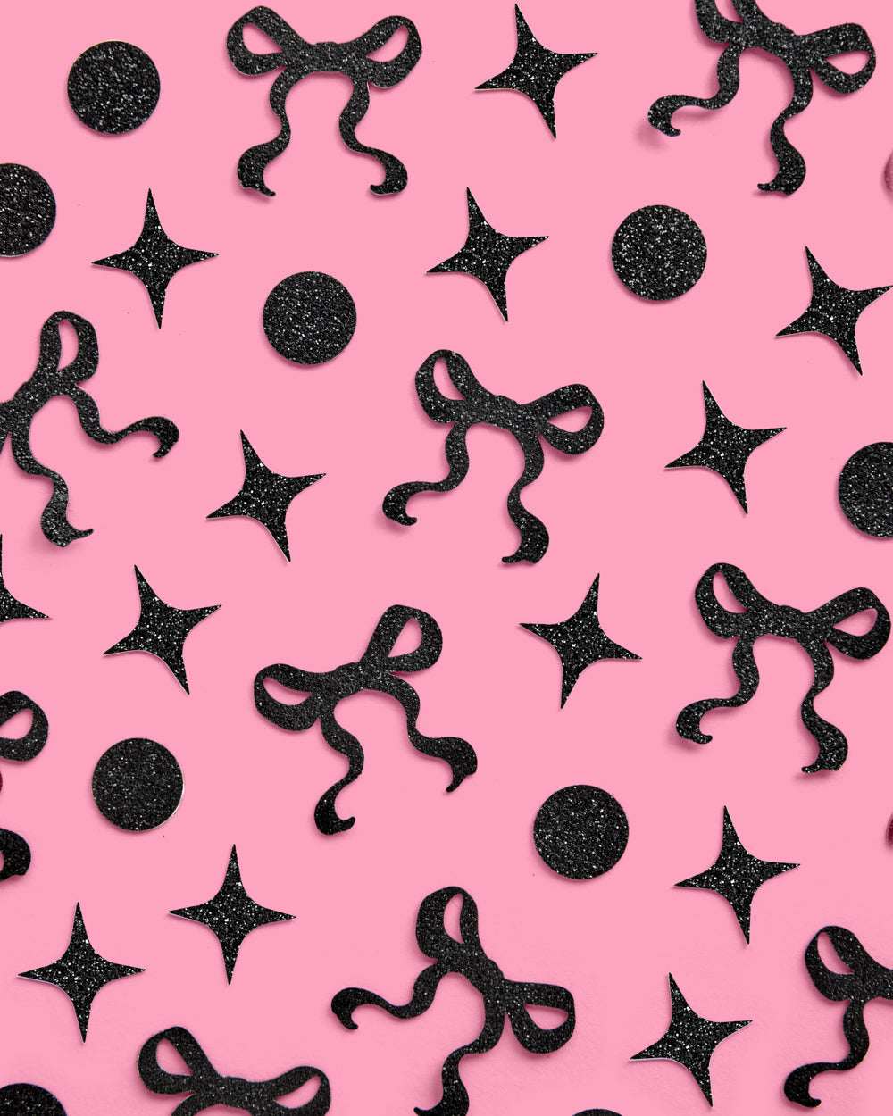 Black decorative bows and stars on a pink background