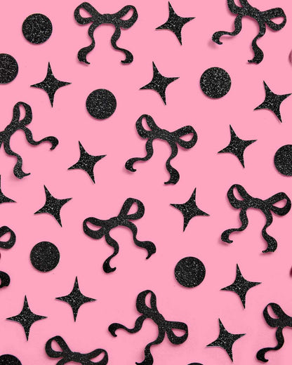 Black decorative bows and stars on a pink background