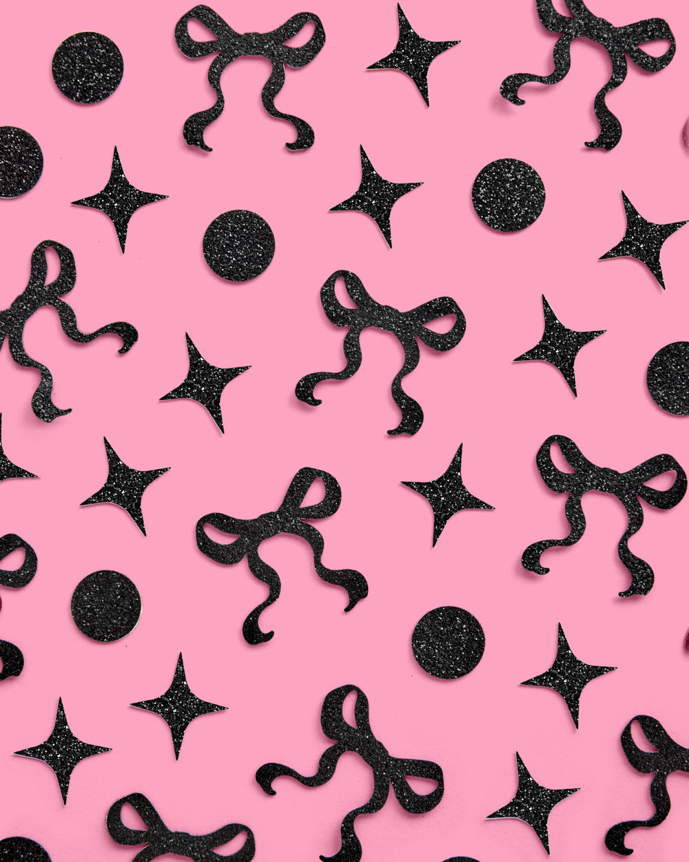 Black decorative bows and stars on a pink background