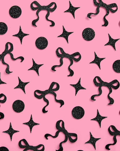 Black decorative bows and stars on a pink background