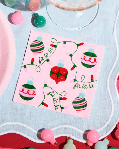 Sheet of Christmas-themed stickers with ornaments and 'fa la la' text on a pink background, surrounded by festive decorations.