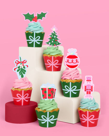 Decorative Christmas-themed cupcake toppers on a pink background