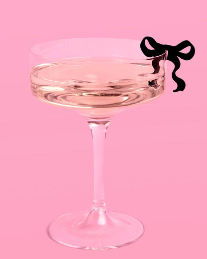 Clear glass with a black bow on a pink background