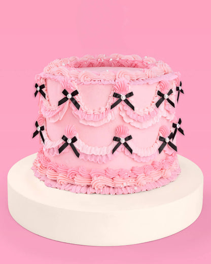 Pink cake with decorative bows on a pink background
