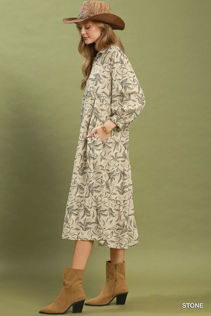 Woman wearing a patterned dress and brown boots against a green background
