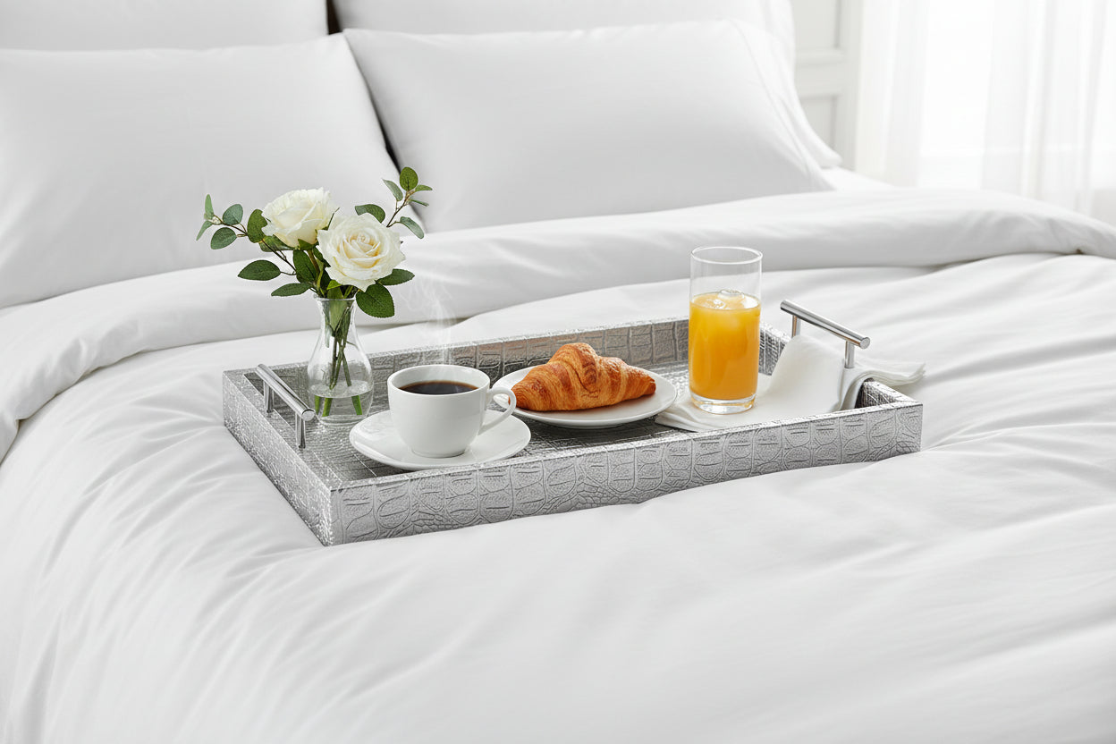 Silver tray with breakfast served  on a white bed. 