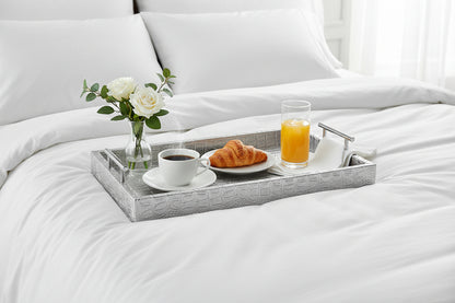 Silver tray with breakfast served  on a white bed. 
