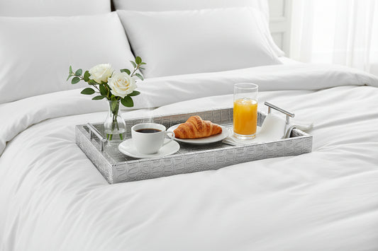 Silver tray with breakfast served  on a white bed. 