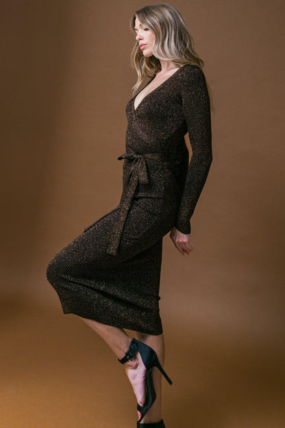Woman wearing a dark brown dress with long sleeves on a brown background