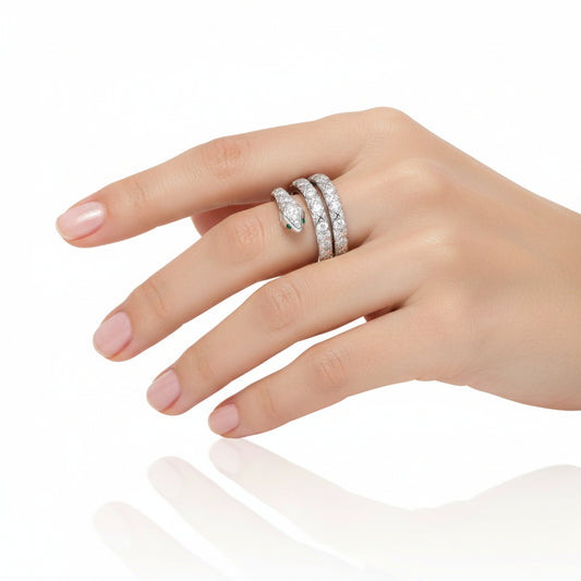 Silver snake-shaped ring with diamond accents on a woman's finger with white background