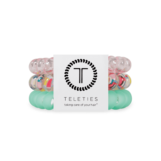 Stack of colorful hair ties with a Teleties label on a green background