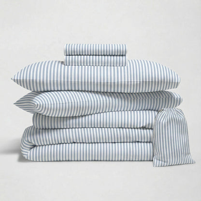 Stack of blue and white striped bedding on a light gray background