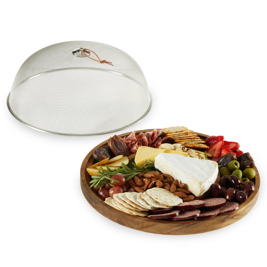Wooden charcuterie board with assorted foods and a metal dome cover on a white background