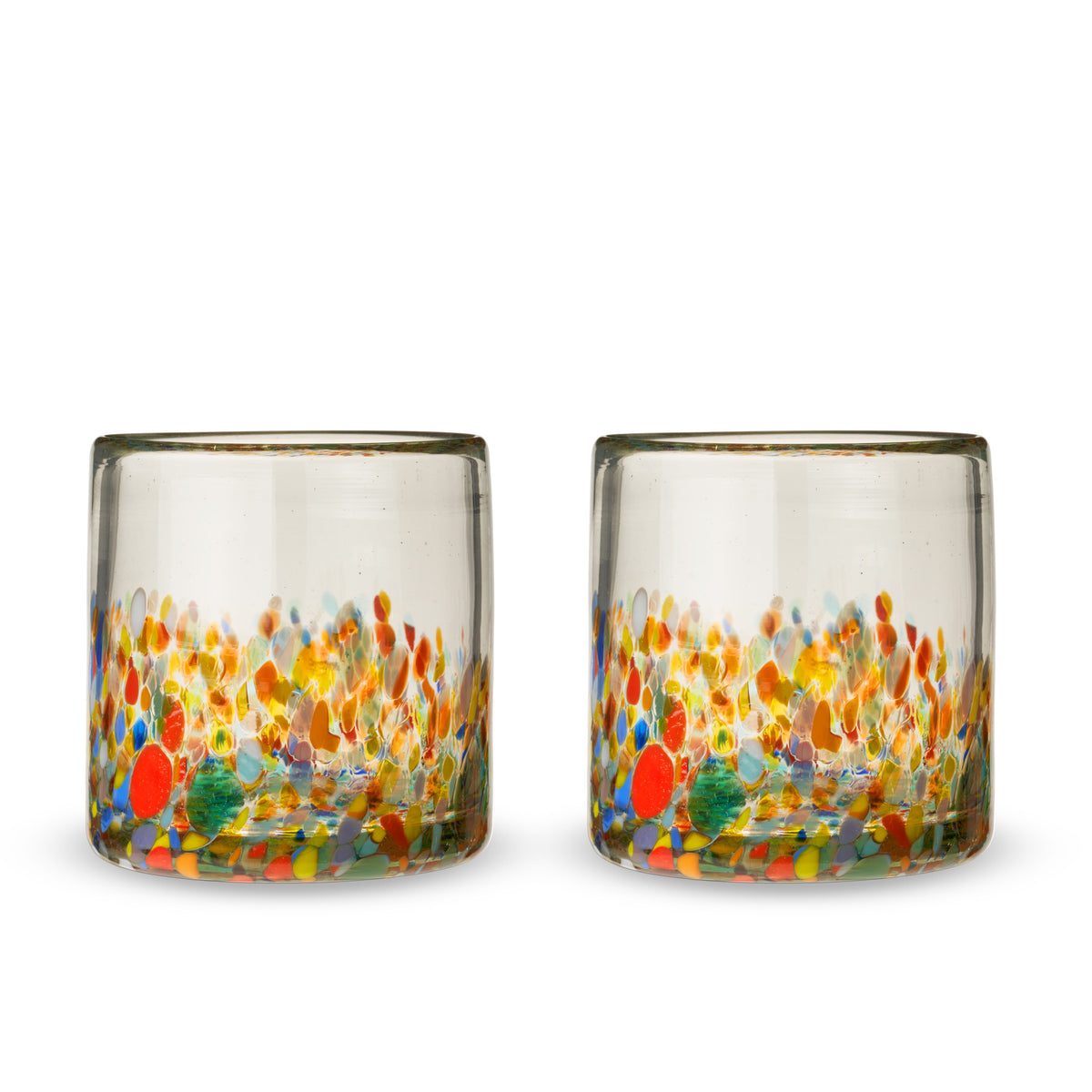 Two empty Segunda Vida Artistico glass tumblers with multicolored speckles around their lower halves.