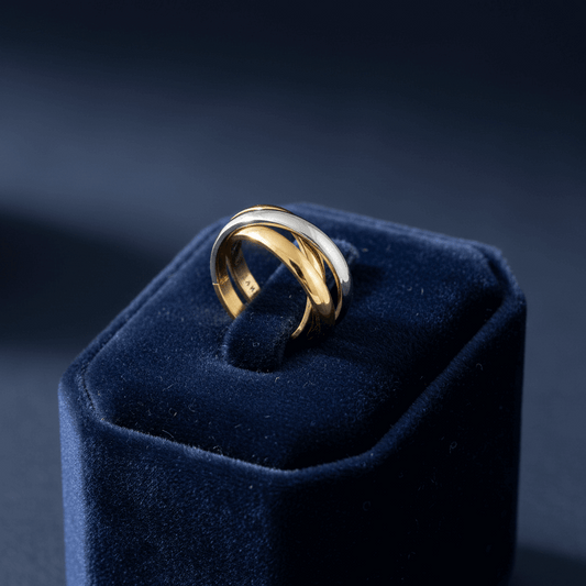 Two-toned gold and silver ring on a velvet jewelry display box.