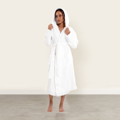 Woman wearing a white robe against a plain background