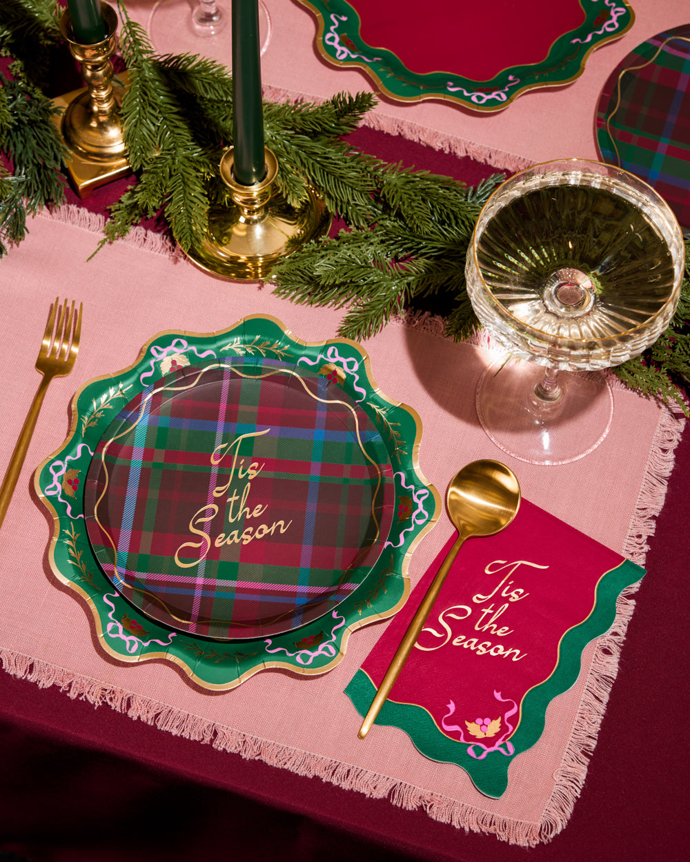 Christmas-themed table setting with plaid plates and pink placemats.
