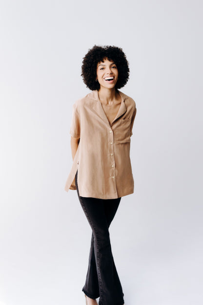 Woman wearing a beige coat and black pants on a white background
