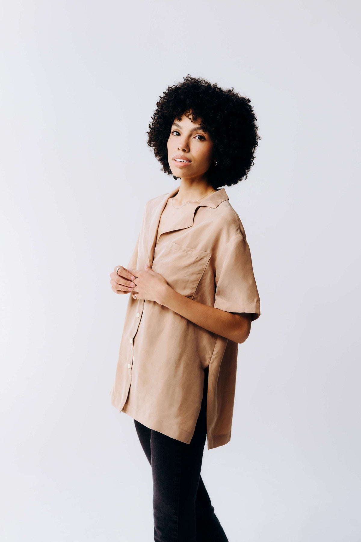 Woman wearing a beige trench coat against a white background