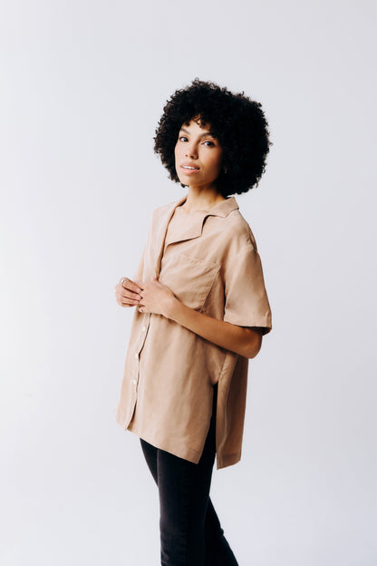 Woman wearing a beige trench coat against a white background