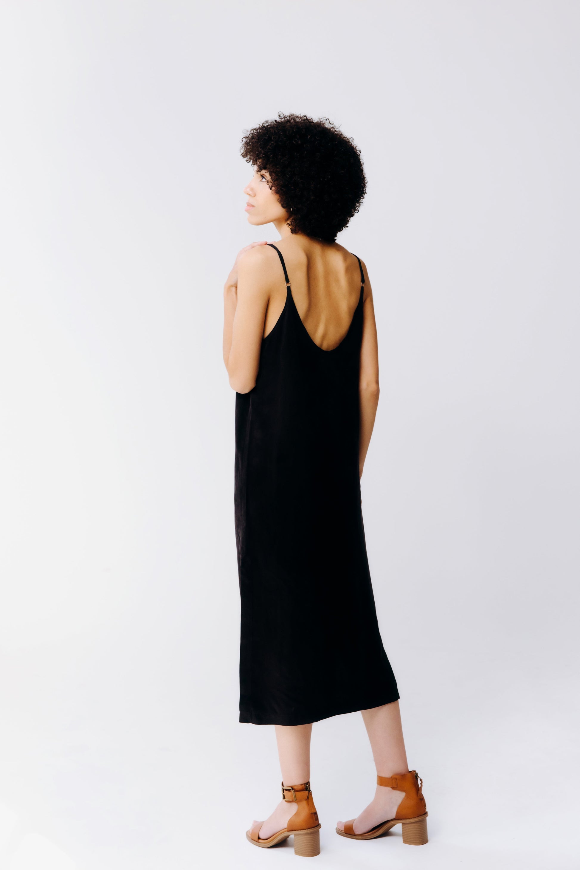 Woman wearing a black sleeveless dress on a white background
