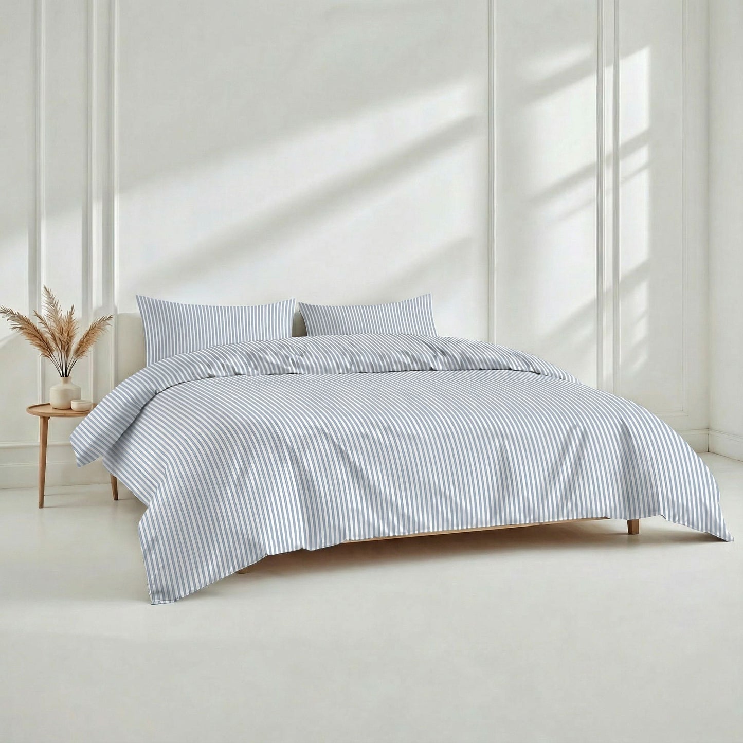 Bed with striped bedding in a bright room with sunlight filtering through.