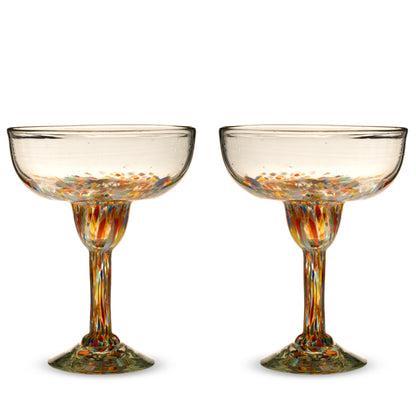 Two empty Segunda Vida Artistico margarita glasses with multicolored speckles in the bowls, stems, and bases.
